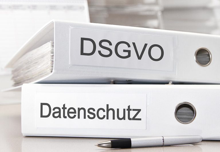 Zwei weiße Aktenordner aufeinander gestapelt mit Datenschutz und DSGVO