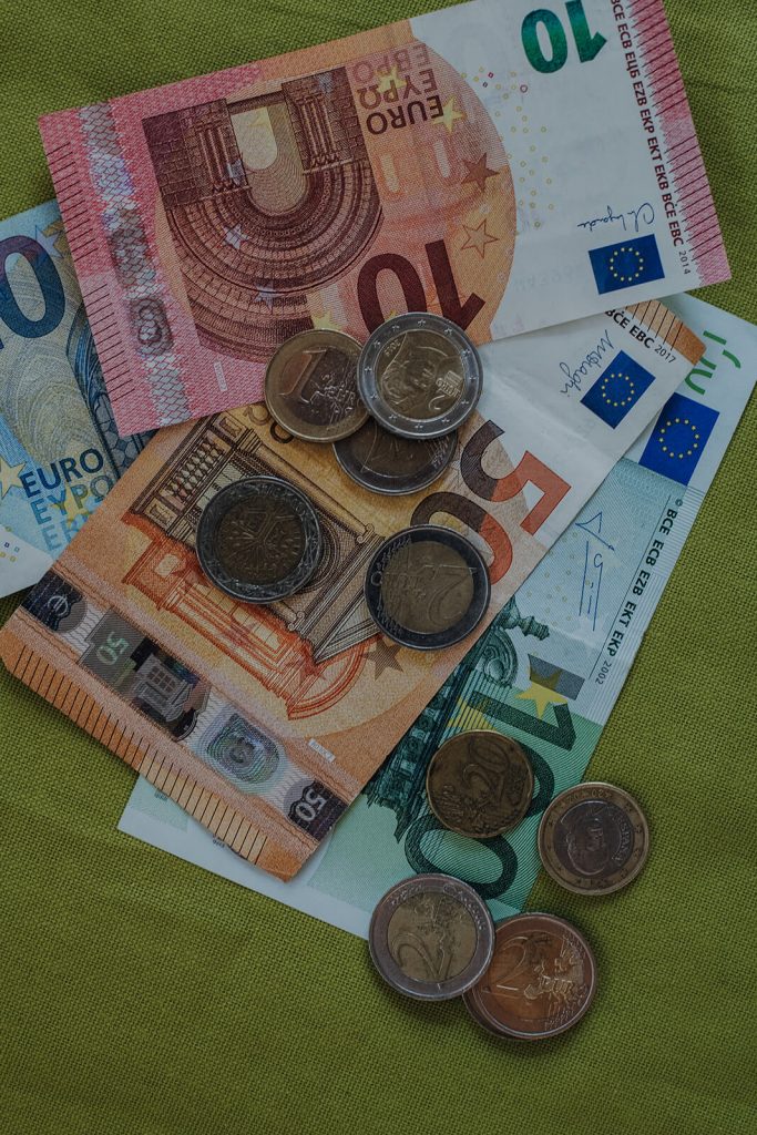 Euro-Geldscheine und Münzen auf grünem Stoff ausgebreitet