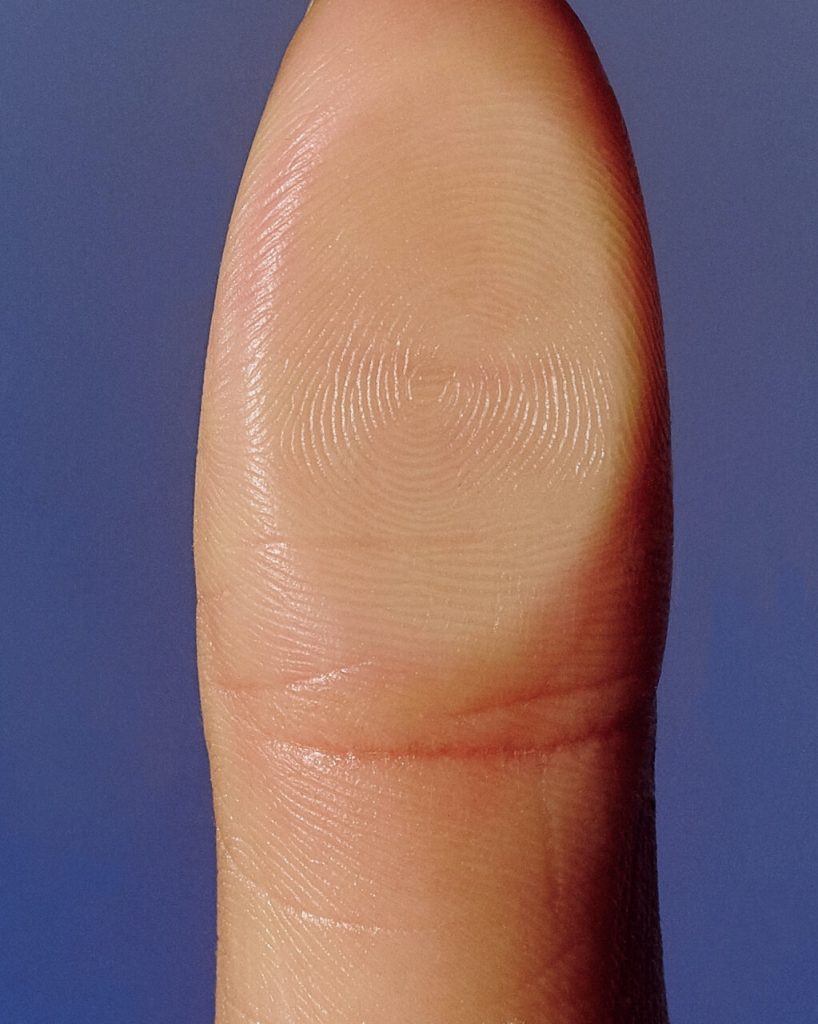 Menschlicher Fingerabdruck vor blauem Hintergrund