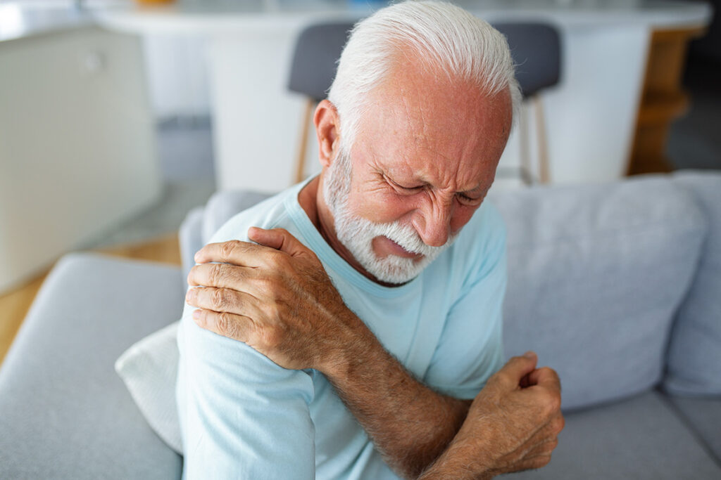 Älterer Mann mit Arthritis im Schultergelenk